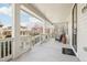 Inviting covered front porch with white columns, railing, and an outdoor welcome mat at 8977 Crossington Way, Lone Tree, CO 80124