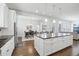Open concept kitchen with white island, cabinets, hardwood floors and stainless steel appliances at 8977 Crossington Way, Lone Tree, CO 80124