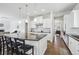 Bright kitchen features a large island with bar seating, pendant lighting, and hardwood floors at 8977 Crossington Way, Lone Tree, CO 80124