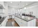 This expansive kitchen is equipped with stainless appliances, white cabinetry, and an oversized island at 8977 Crossington Way, Lone Tree, CO 80124