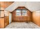 Finished attic space featuring wood paneling, built-in storage, and natural light from two windows at 1390 W Gill Pl, Denver, CO 80223