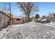 Backyard featuring a shed and parking in a fenced yard and with snow covered ground at 1390 W Gill Pl, Denver, CO 80223