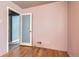 Bright bedroom featuring hardwood floors, fresh paint, and a door leading to other rooms at 1390 W Gill Pl, Denver, CO 80223