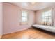 Sunny bedroom featuring hardwood floors and vintage windows for natural light at 1390 W Gill Pl, Denver, CO 80223