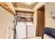 Laundry room with washer and dryer, overhead shelving, and linoleum flooring at 1390 W Gill Pl, Denver, CO 80223