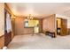 Bright living room with pass-through to kitchen, wood paneled walls, and vintage chandelier at 1390 W Gill Pl, Denver, CO 80223