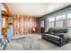 Cozy living room featuring a wood paneled wall, large window and a comfortable leather sofa at 1390 W Gill Pl, Denver, CO 80223