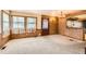 Spacious living room with wood paneling, large windows, and an opening to a bar area at 1390 W Gill Pl, Denver, CO 80223