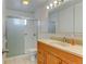 Bathroom featuring vanity with cabinets and drawers, white tiles, and standing shower with glass door at 315 E 112Th Dr, Northglenn, CO 80233