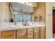 Double vanity bathroom with a large mirror and wood cabinets at 6460 E 165Th Ct, Brighton, CO 80602