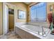 Bathroom featuring a large soaking tub and window at 6460 E 165Th Ct, Brighton, CO 80602