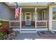 Front porch with American flag, and welcoming entryway to the house at 6460 E 165Th Ct, Brighton, CO 80602