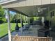 Covered patio featuring ceiling fans, fireplace, outdoor kitchen, and porch swing overlooking a lush green backyard at 4827 S Lewis Ct, Littleton, CO 80127