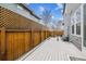 Backyard with wooden fence, gray deck, and gravel walkway between homes at 8157 E 53Rd Dr, Denver, CO 80238