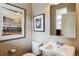 Cozy half bathroom featuring modern vanity, mirror, and stylish decor at 8157 E 53Rd Dr, Denver, CO 80238