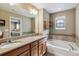 Bathroom featuring double vanity, soaking tub, stained glass window and tile accents at 8157 E 53Rd Dr, Denver, CO 80238