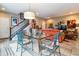 Open dining space with glass table, decorative rug, and staircase access at 8157 E 53Rd Dr, Denver, CO 80238