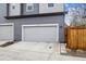 Two-car garage with gray siding and driveway plus wood fence at 8157 E 53Rd Dr, Denver, CO 80238