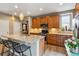 Modern kitchen boasts granite counters, stainless appliances, wooden cabinets and stylish pendant lighting above the island at 8157 E 53Rd Dr, Denver, CO 80238