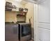 Well-organized laundry room with stainless steel appliances, storage shelves, and a clean white door at 8157 E 53Rd Dr, Denver, CO 80238