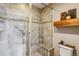 Modern bathroom with tile shower, bench seat, glass door, decorative shelf, and neutral color palette at 8157 E 53Rd Dr, Denver, CO 80238