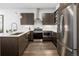 Modern kitchen with stainless steel appliances, white countertops, and dark wood cabinetry at 1898 S Bannock St # 103, Denver, CO 80223