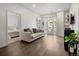 Sunlit living room with hardwood floors, neutral décor, and a doorway to the bedroom at 1898 S Bannock St # 103, Denver, CO 80223