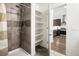 Stylish bathroom showing tiled shower, linen closet, and kitchen view at 1898 S Bannock St # 103, Denver, CO 80223