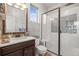 Modern bathroom with a walk-in shower, a vanity, and a window with natural light at 947 Buffalo Ridge Rd, Castle Pines, CO 80108