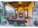 Cozy covered patio with a stone fireplace and comfortable seating, perfect for relaxing outdoors at 947 Buffalo Ridge Rd, Castle Pines, CO 80108