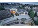 Aerial view of stately home featuring a manicured lawn, three car garage, and a covered entryway at 947 Buffalo Ridge Rd, Castle Pines, CO 80108