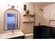 Stylish bathroom with dark vanity, shelves, and glass enclosed shower with gold accents at 13420 Lafayette St, Thornton, CO 80241