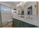 Bathroom with dual vanity, gold fixtures, tub-shower combo, and window at 13420 Lafayette St, Thornton, CO 80241