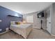 Comfortable bedroom with a blue accent wall, mounted TV, and ample natural light from the window at 13420 Lafayette St, Thornton, CO 80241