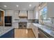 Modern kitchen featuring a large gourmet stove and hood, custom backsplash, and a farmhouse sink at 13420 Lafayette St, Thornton, CO 80241