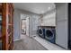 Well-lit laundry room featuring marble tile floors, modern washer/dryer, cabinets and a doorway to a bedroom at 13420 Lafayette St, Thornton, CO 80241