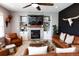Bright living room with a brick fireplace, built-in shelves, and tan leather furniture at 13420 Lafayette St, Thornton, CO 80241