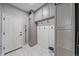 Functional mudroom with built-in storage cabinets, hooks, and marble-look tile flooring at 13420 Lafayette St, Thornton, CO 80241