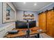 Office with wooden barn doors, shelving, modern desk, neutral walls, and carpeted floors at 13420 Lafayette St, Thornton, CO 80241
