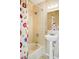 Bathroom featuring a shower-tub combination and pedestal sink with decorative shower curtain at 751 Poplar St, Denver, CO 80220