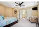 Bright bedroom with a chair, mounted TV, and a view into the adjacent hallway at 751 Poplar St, Denver, CO 80220