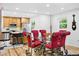 Bright dining room features a glass table with red chairs, modern lighting, and hardwood floors at 751 Poplar St, Denver, CO 80220