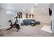 Finished basement recreation area with fireplace and exercise bike at 6062 Garrison St, Arvada, CO 80004