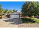 Brick ranch home with attached garage and mature tree at 6062 Garrison St, Arvada, CO 80004