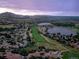 Scenic aerial view of a golf course, lakes, and houses against a mountain backdrop at 16671 Red Cliff Cir, Morrison, CO 80465