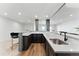 Wet bar with sink, dark wood cabinets, light countertops, and stainless-steel sink at 16671 Red Cliff Cir, Morrison, CO 80465
