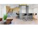 Basement bar with modern stools, stone wall accents, and access to the staircase at 16671 Red Cliff Cir, Morrison, CO 80465