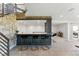 Finished basement with a bar area, stone wall, and modern black and gold bar stools at 16671 Red Cliff Cir, Morrison, CO 80465