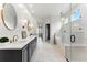 Bright bathroom with a freestanding tub, glass shower, and double vanity with modern light fixtures at 16671 Red Cliff Cir, Morrison, CO 80465