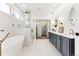Bright bathroom with a freestanding tub, glass shower, and double vanity with gold fixtures at 16671 Red Cliff Cir, Morrison, CO 80465